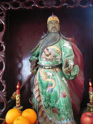A Guan Yu statue holding the guan dao in the right hand.