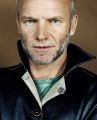 Sting, musician (a Buddhist), with collar up