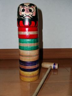 Daruma Otoshi. The Daruma character, hammer, and rainbow-colored pieces.