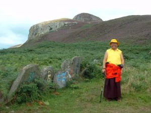 Lama Yeshe Losal Rinpoche on Holy Island with stones decorated with the mantra Om Mani Peme Hung